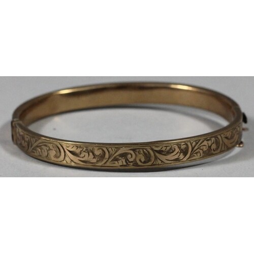 A 9ct gold hollow bangle, with engraved front, 10 gms.