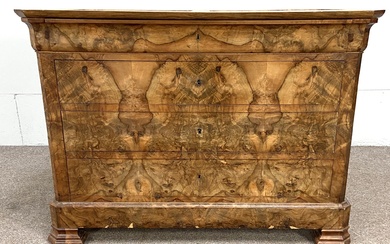 A Biedermeier walnut veneered commode, 19th century, with an ogee moulded frieze drawer over three