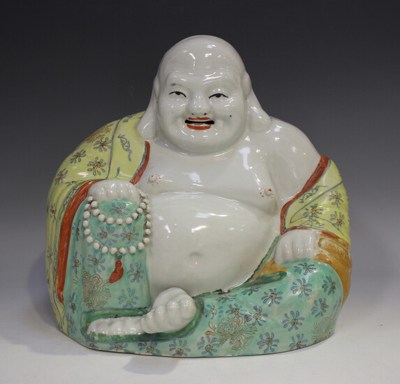 A Chinese porcelain figure of a seated smiling Buddha, early 20th century, modelled wearing an open