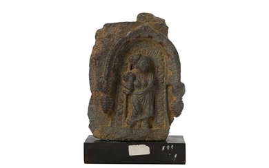 A GREY SCHIST CARVING OF A FEMALE ATTENDANT UNDER AN ARCHED TORANA Ancient region of Gandhara, 2nd - 3rd century