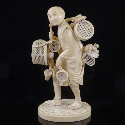 A Japanese ivory okimono of a basket seller, Meiji Period, w...