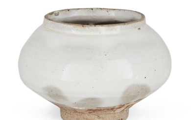 A Korean stoneware Buncheong small jar, Joseon dynasty, of compressed globular form on a slightly tapered short foot, painted with white slip and covered with a clear glaze that falls short of the foot, 6.9cm high