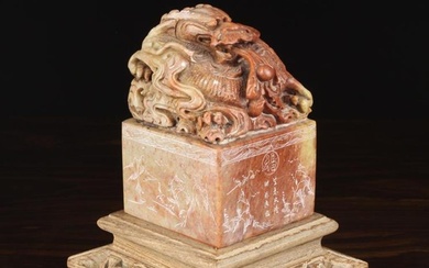 A Large Chinese Carved Red & Pale Green Mottled Stone Seal surmounted by a scrolling dragon with pea