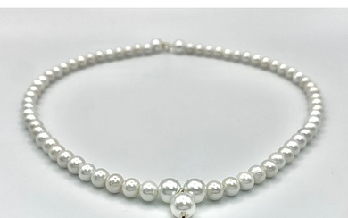 A faux pearl necklace with a 14 K yellow gold clasp and a sm...