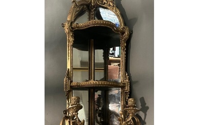 A gilt framed shelved corner mirror or girondele with two ar...