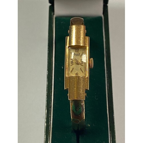 A lady's 18ct gold wristwatch, to hinged bangle