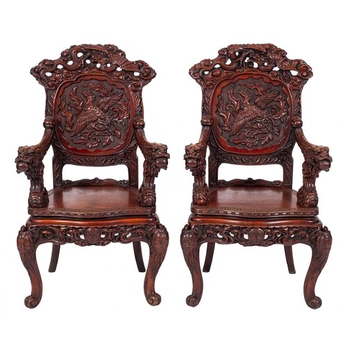 A pair of Chinese carved hardwood elbow chairs, early 20th c...