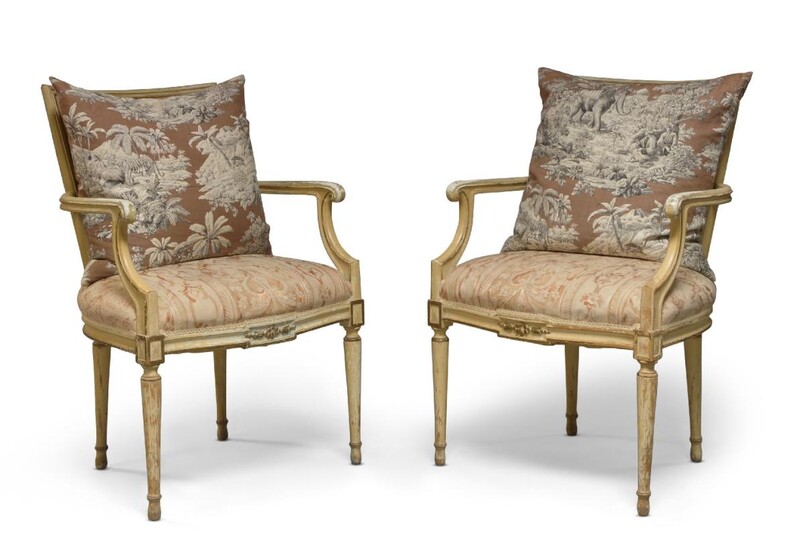A pair of French Louis XVI style cream upholstered open armchairs, early 20th century, with concave canework backs, upholstered seats, curved arm supports, raised on turned tapered legs, complete with loose cushions, 93cm high, 61cm wide, 45cm deep...