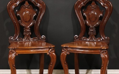 A pair of Victorian mahogany hall chairs, each with a shaped...
