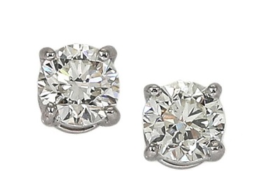 A pair of solitaire diamond ear studs each set with a diamond...