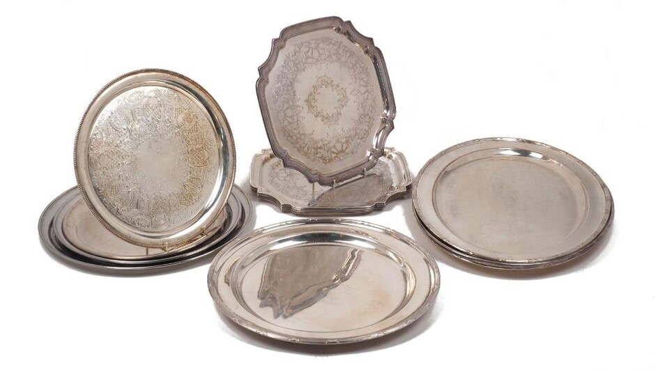 A quantity of silver plated trays and platters including: a twin-handled rectangular tray with pierced sides and four paw feet, 54cm long; two large shaped oval trays, 56.5cm long; a large rectangular tray with reeded crossover design rim and four...