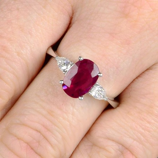 A ruby and pear-shape diamond three-stone ring. Ruby