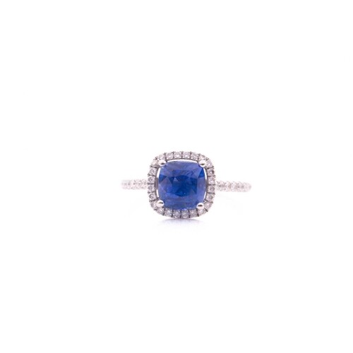 A sapphire and diamond cluster ring; the cushion cut sapphir...