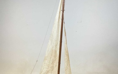 A vintage wooden pond yacht with linen sails, on wooden...
