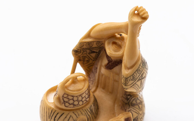 An Antique Japanese Carved Ivory Netsuke of a Merchant