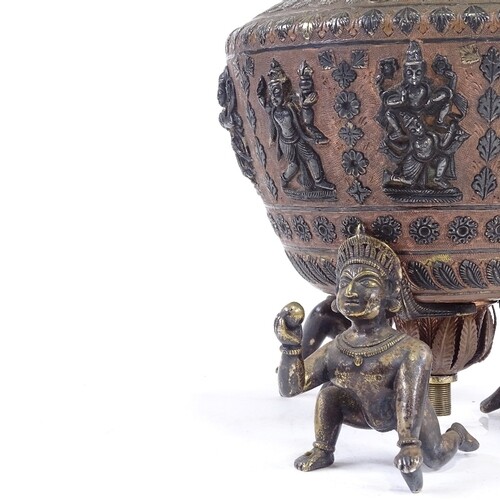 An Indian bronze and silver inlaid lamp base supported by 3 ...