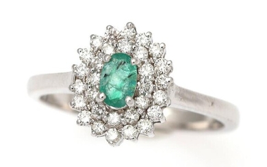 SOLD. An emerald- and diamond ring set with an oval-cut emerald encircled by numerous brilliant-cut diamonds, mounted in 14k white gold. W. 11 mm. Size 52. – Bruun Rasmussen Auctioneers of Fine Art