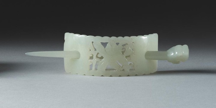 CHINESE CELADON JADE HAIRPIN Curved rectangular form, with pierced design of a child. Pin with dragon head. Length 5.25".