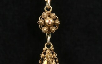 Gold chain with filigree pendant.