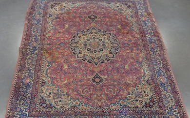 IRAN : Grand tapis en laine à fond rose. Dimensions : 340x250 cm (usures)