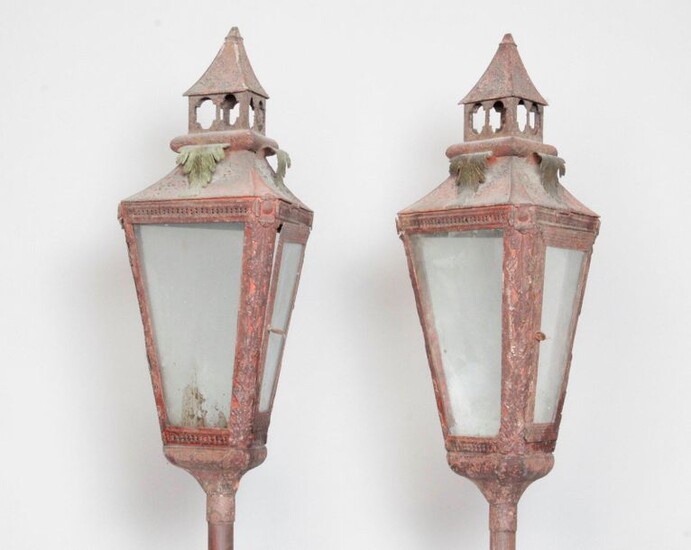 Processional lanterns of triangular shape in painted sheet metal with palmette and rosette decoration. Mounted on a wooden pole. 19th century. With bases. H : 203 cm