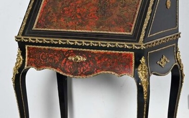 Secrétaire de pente en bois noirci, à décor marqueté de laiton sur fond d'écaille rouge, ouvrant par un abattant formant pupitre, reposant sur quatre pieds cambrés. Ornementation de bronze et de laiton doré