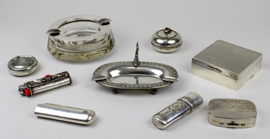Set of smoking accessories, partly silver, partly silver-plated, M. - 2nd half 20th century, consisting of: Glass ashtray with mount made of 800 silver, ashtray with handle designed as a fish; lighter, baroque style cover, 925 silver; lighter cover...