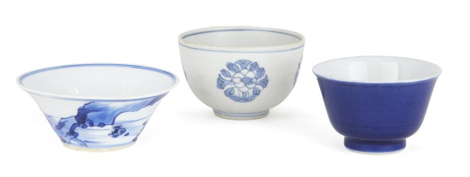 Three Chinese porcelain teabowls, 17th-19th century, one painted with a scholar sat atop a rocky outcrop by the sea, another shipwreck teabowl decorated with four flowerheads, the third a blue monochrome teabowl, 3.4cm-4.5cm high (3)
