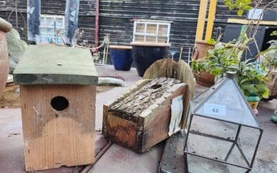 Two wooden bird houses and a small glass terrarium plant hol...