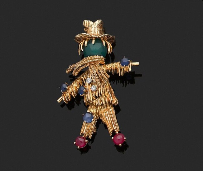 VAN CLEEF & ARPELS. CLIP de REVERS in 750 thousandths yellow gold engraved with a scarecrow, the head adorned with a ball of chrysoprase, the body set with round brilliant diamonds, sapphires and cabochon rubies. Signed and numbered (B 4802 - 750 c...