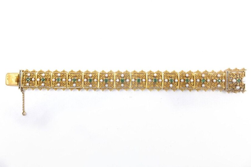 18th C. BRACELET in 18K yellow gold composed of a succession of square geometrical patterns retaining an emerald and four white pearls (untested) (missing 8 pearls). Length: 21 cm. Gross weight : 54.26 gr. A gold, emerald and pearl bracelet.