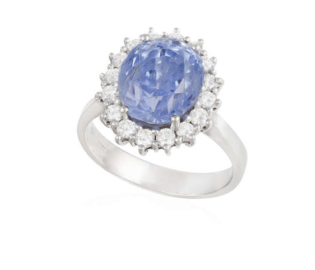 A SAPPHIRE AND DIAMOND CLUSTER RING, composed of...