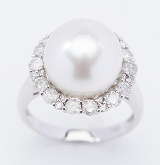 A SOUTH SEA PEARL AND DIAMOND RING - Of cluster design, featuring a round pearl of silver white hues measuring 12.5mm, within a bord...
