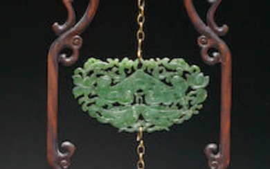 A SPINACH-GREEN JADE RETICULATED MUSICAL STONE SUSPENDING A DOUBLE-FISH PENDANT