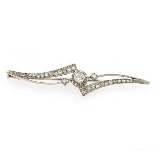 A diamond brooch set with an old-cut diamond flanked by two square-cut and numerous single-cut diamonds, mounted in 18k white gold. L. 6 cm.