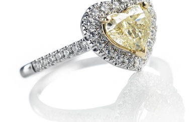 A diamond ring set with a heart-shaped brilliant-cut natural fancy yellow diamond weighing app. 1.00 ct. encircled by numerous brilliant-cut diamonds weighing a total of app. 0.95 ct., mounted in 18k gold and white gold. Colour: River (E). Clarity:...