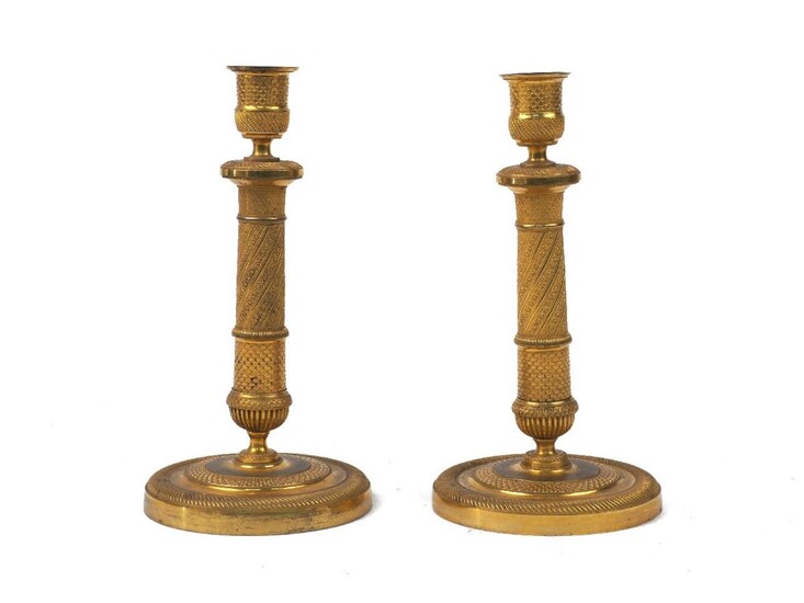 A pair of Charles X ormolu candlesticks, second quarter 19th century, of column form with urn surmount, with chased floral and fish scale motifs, 23cm high