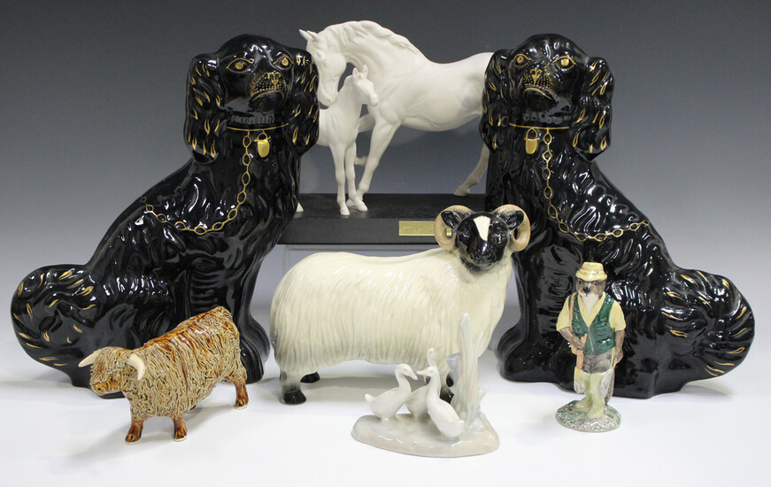 A pair of Jackfield type black glazed Staffordshire spaniels, late 19th century, with gilt detail, h