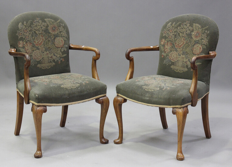 A pair of early 20th century walnut framed shepherd's crook elbow chairs, each upholstered in n