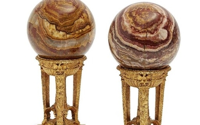 A pair of gilt-metal athenienne, late 20th century, each supporting an associated onyx sphere, 19cm high (2)