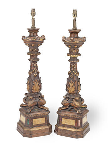 A pair of large late 18th / early 19th century Italian carved and parcel gilt and stained wood alter candlesticks later adapted as lamp bases