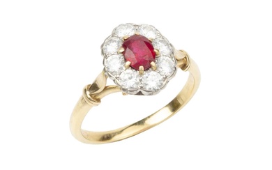 A ruby and diamond cluster ring, the oval cut ruby...
