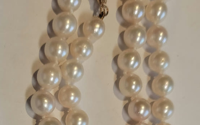 A uniform pearl necklace with a 14k yellow gold clasp