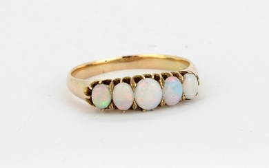A yellow metal (tested high carat gold) ring set with five cabochon oval cut opals, (P).