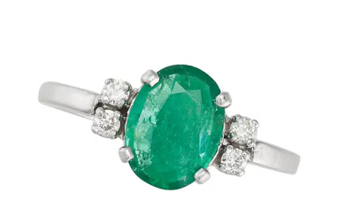 AN EMERALD AND DIAMOND RING set with an oval cut e ...