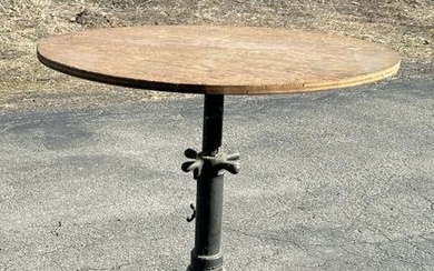 Adjustable industrial iron base table w/plywood top, measures 34" W X 30" H.