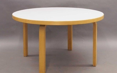 After Alvar Aalto, a coffee table, the circular white laminate top raised on bent ply birch supports, 56cm high, 100cm diameter