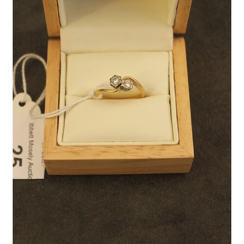 An 18ct gold two stone diamond cross-over dress ring, size N...