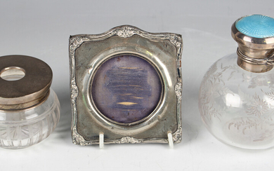 An Edwardian silver mounted shaped square photograph frame with circular aperture and foliate rim, C
