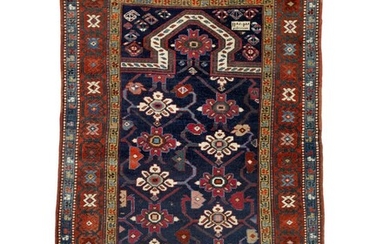 SOLD. An antique dated Karabagh prayer rug, Caucasus. Mirab on a blue field with an all over linked stylized blossom design. Dated 1330=1910. 152 x 95 cm. – Bruun Rasmussen Auctioneers of Fine Art